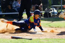 Crisy McSavaney successfully slides into home base for a run for the United Flames in the Waratah League softball at French Fields. Picture by Bernard Humphreys