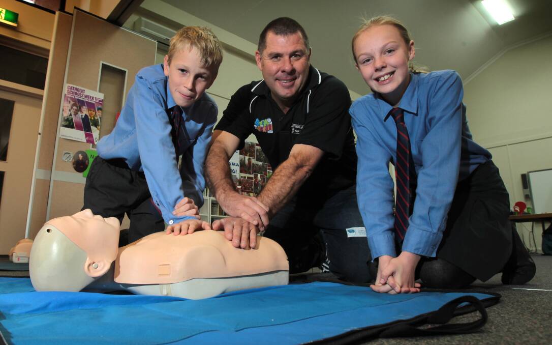 DR ABC: Lifeguard Cameron McFarlane teaches St Joseph's Primary School students James Molloy, 11, and Sharni Gray, 12, proper CPR techniques. Picture: Les Smith 