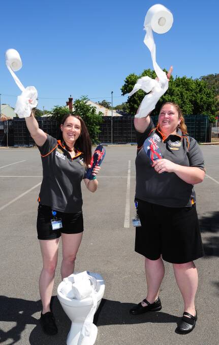 GOOD FUN: Farmers Home bar attendant Jess Stemp and assistant manager Nicole Anderson practise for the Australia Day dunny roll and thong throw. Picture: Kieren L Tilly
