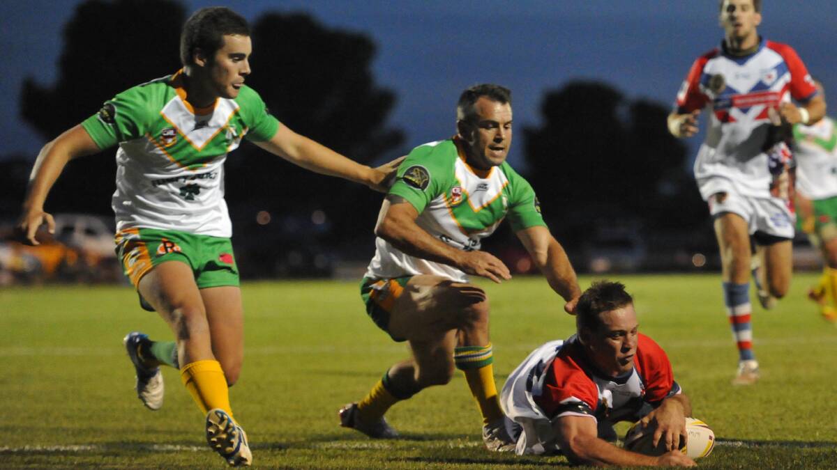 Kangaroos' Brent Blackstock goes over for a try as Orange CYMS' Luke Petrie and Sam Jones look on in last year's West Wyalong Knockout.