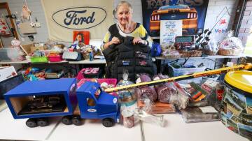 Riverina Ford Owners Club President Raewyn Gilchrist reveals just a portion of the many unique items the club will auction off for charity. Picture by Les Smith 