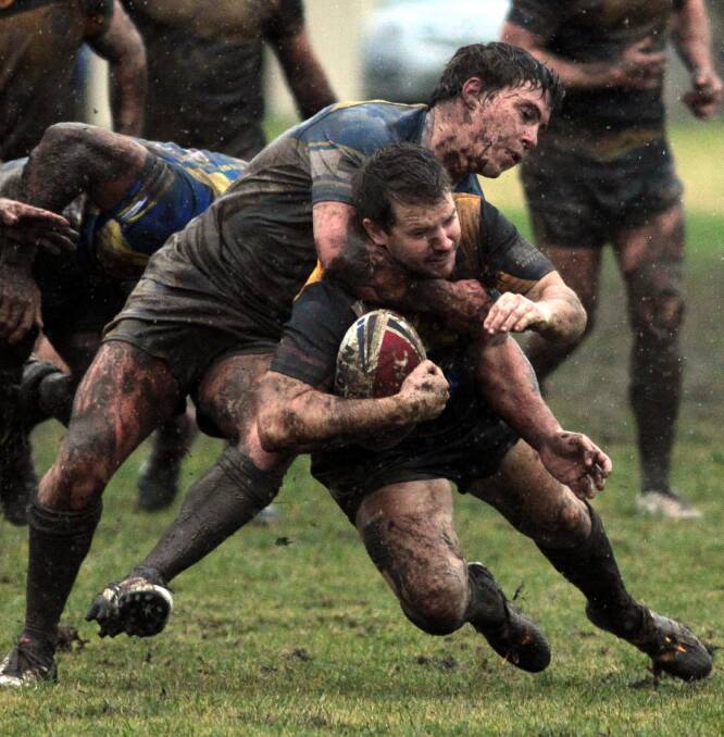 MUD BATH: Trent Schubach and Ben Reardon ignore the winter weather during the Junee and Gundagai Group 9 rugby league match at Junee. Picture: Les Smith
