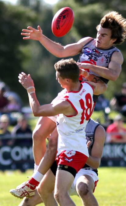 FLYING HIGH: Lachlan Moore and Alex Blissett clash during the Griffith Swans and Collingullie match at Ganmain sportsground. Picture: Les Smith