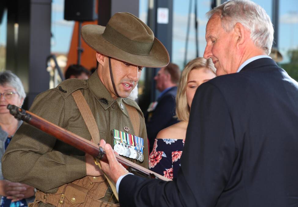 RESPECT: Wagga mayor Greg Conkey admires the rifle being carried by Corporal Michael Pilia'e-Smith during the Beersheba Commemoration. Picture: Kieren L Tilly