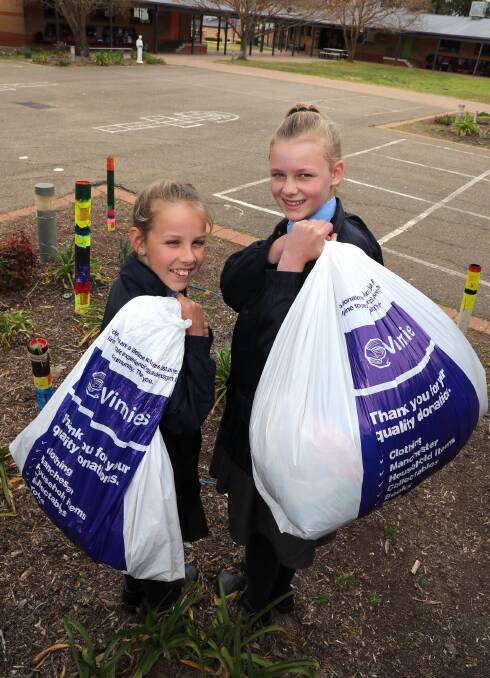 GIVING: Molly McPherson, 11, and Amelia Deal, 12, are ready with some donations for St Vincent de Paul. Picture: Les Smith