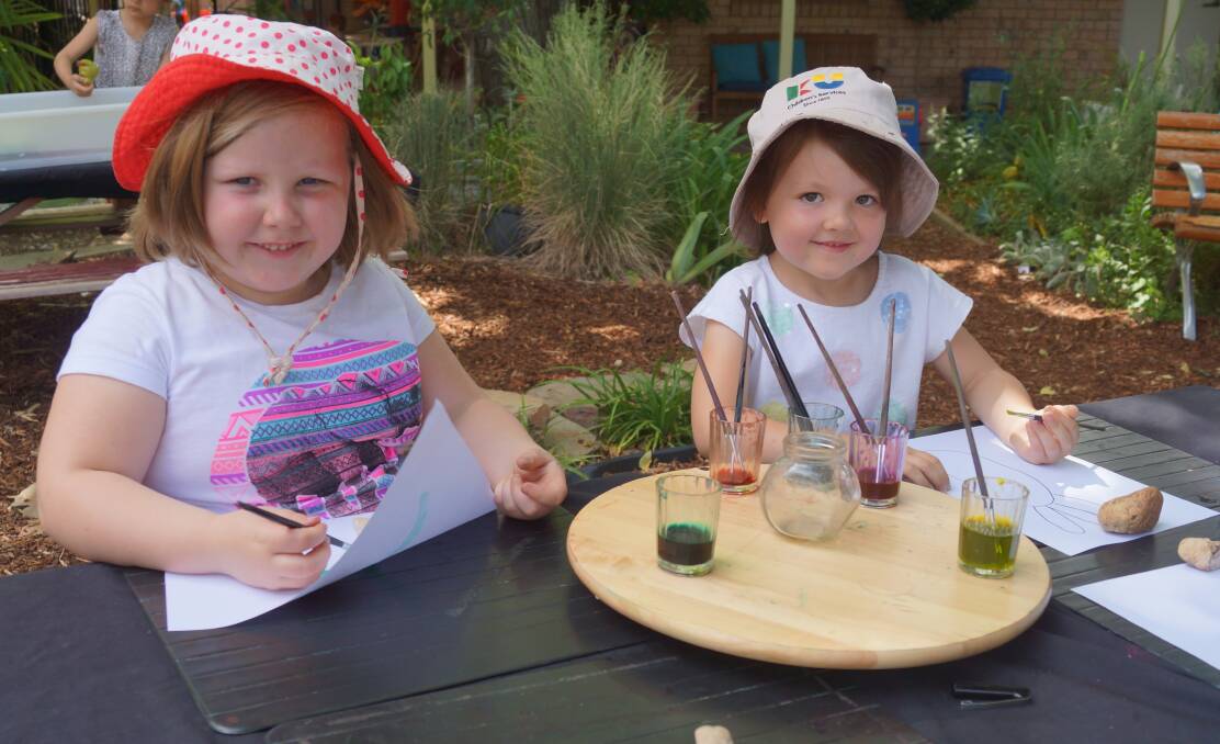 Artistic: Zoe White, 5, and Mia Patton, 5, enjoy painting in the outdoor area at KU Kangaroo. 