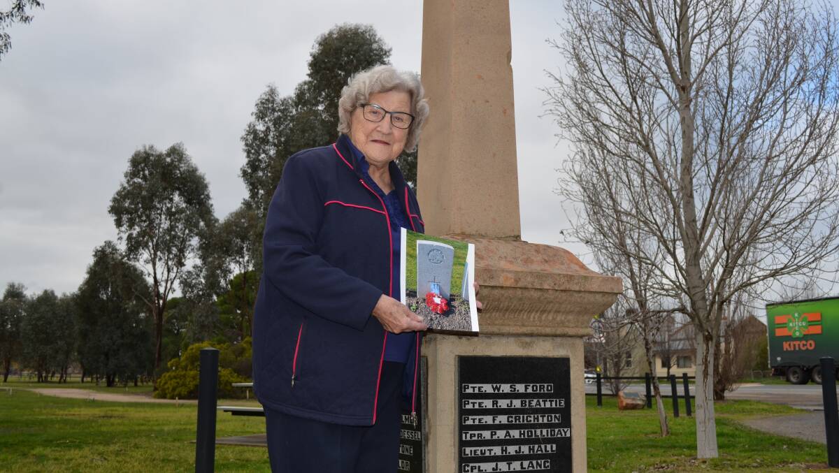 LEST WE FORGET:  Pauline McGilvray at Uranquinty's World War I memorial with a photo of her uncle's grave in France. Picture: Ken Grimson