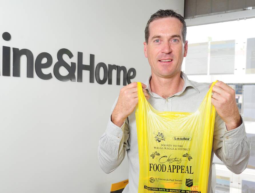 IN THE BAG: Mathew Longmore urges Wagga residents to support the Leader Christmas food appeal on Sunday. Volunteers will start collecting donations from 9am. Picture: Kieren L Tilly