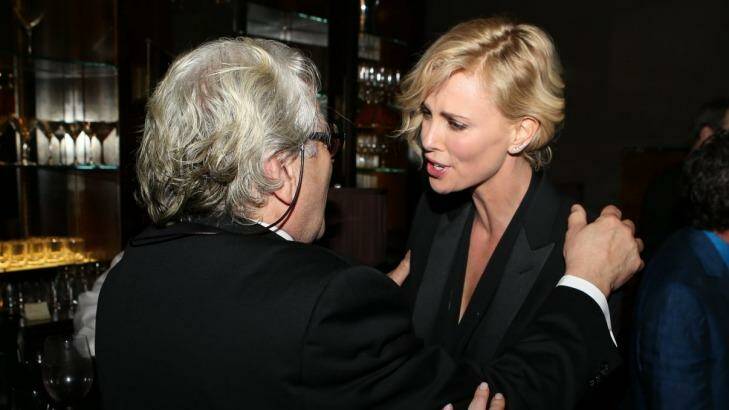 George Miller speaking with Charlize Theron at the pre Oscar party. Photo: Karl Larsen/Coleman-Rayner