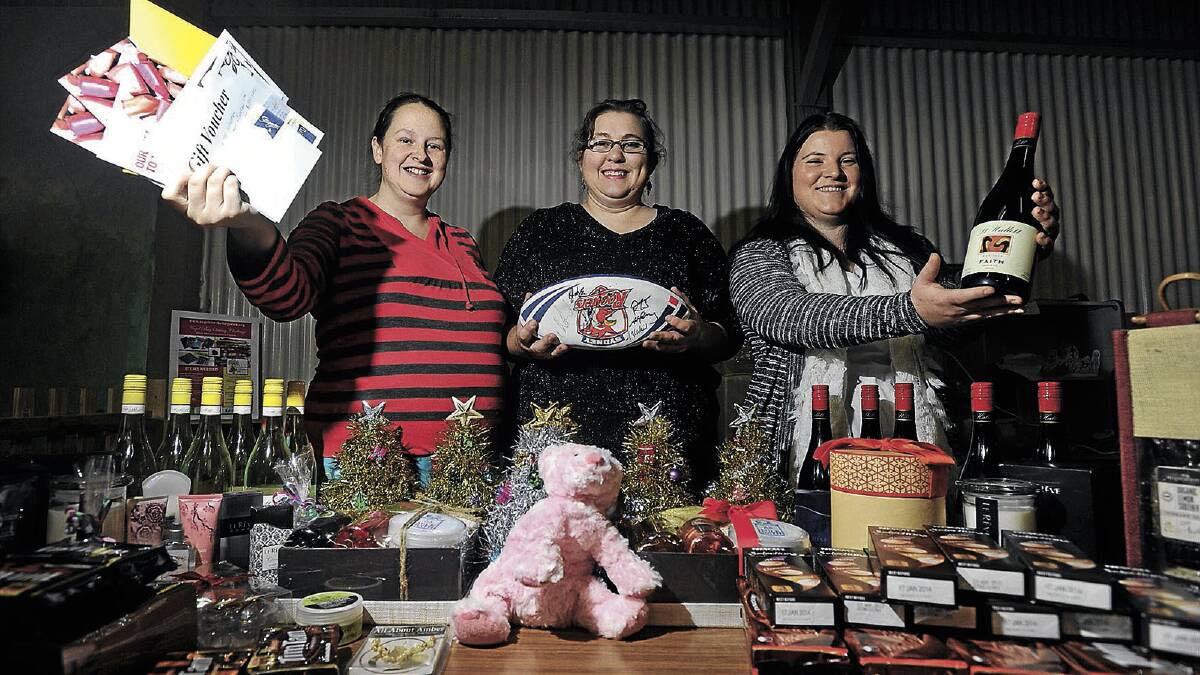 Angels for the Forgotten volunteers – (from left) Samantha Button, Melina Skidmore and Nicole Baillie – show off some of the prizes on offer at the charity’s upcoming fund-raiser trivia night. Picture: Addison Hamilton