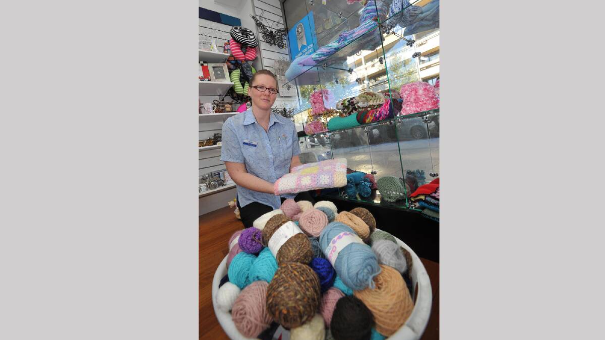 WINTER WARMTH: Michael O’Reilly Chemist employee Loretta Maloney helps promote the Guardian Angel Knitting Program in the city. Picture: Michael Frogley