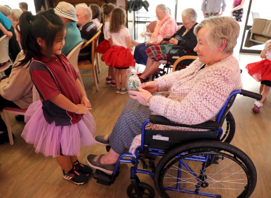 GIFT OF FRIENDSHIP: Cici Jiao, 6, presents a gift to Anne McCoullough following the Wagga Christian College Christmas concert for residents at BaptistCare Caloola Aged Care Centre. Picture: Les Smith