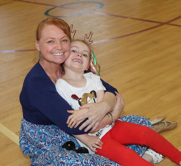 FESTIVE FUN: Alice Lyons, 5, gives her mum, Bindee Jobe, a big cuddle at the Henschke Primary School kindergarten Christmas concert last week. Picture: Les Smith