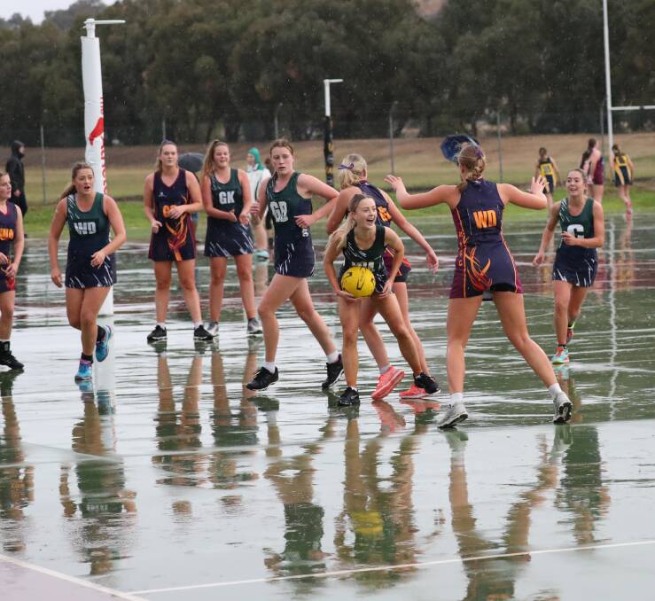 WET DAY: Mater Dei and The Riverina Anglican College battle for the Tracey Gunson Shield at Wagga netball courts in very cold and wet conditions. Picture: Les Smith