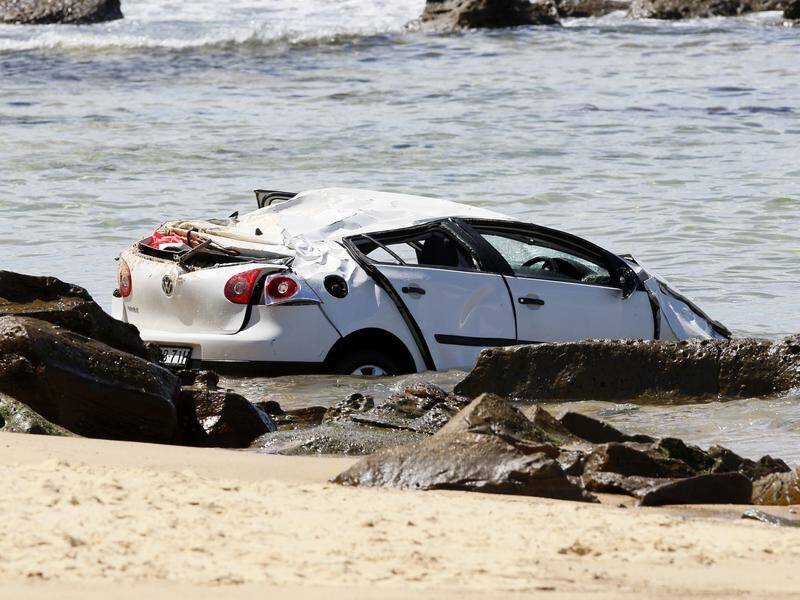 A Newcastle driver has been charged after crashing her car over a cliff and onto the beach below.